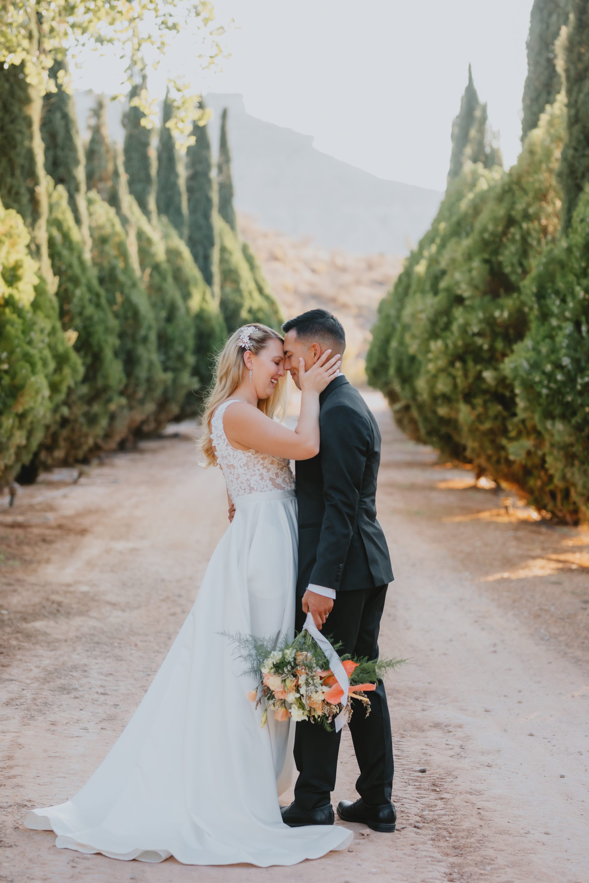 Kate and Manny kissing among cypress trees Southern Utah wedding