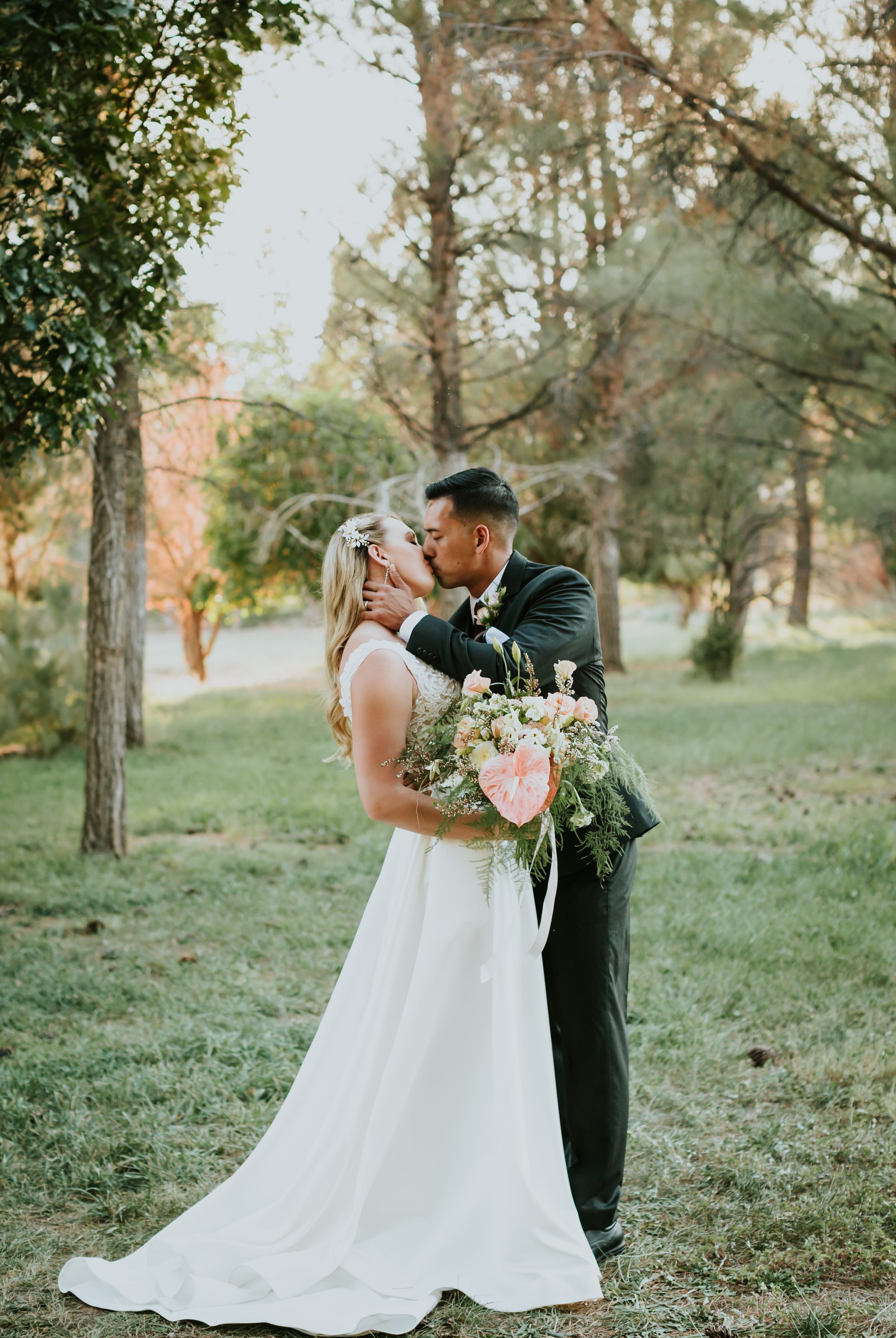 Kate and Manny kiss forest Southern Utah wedding