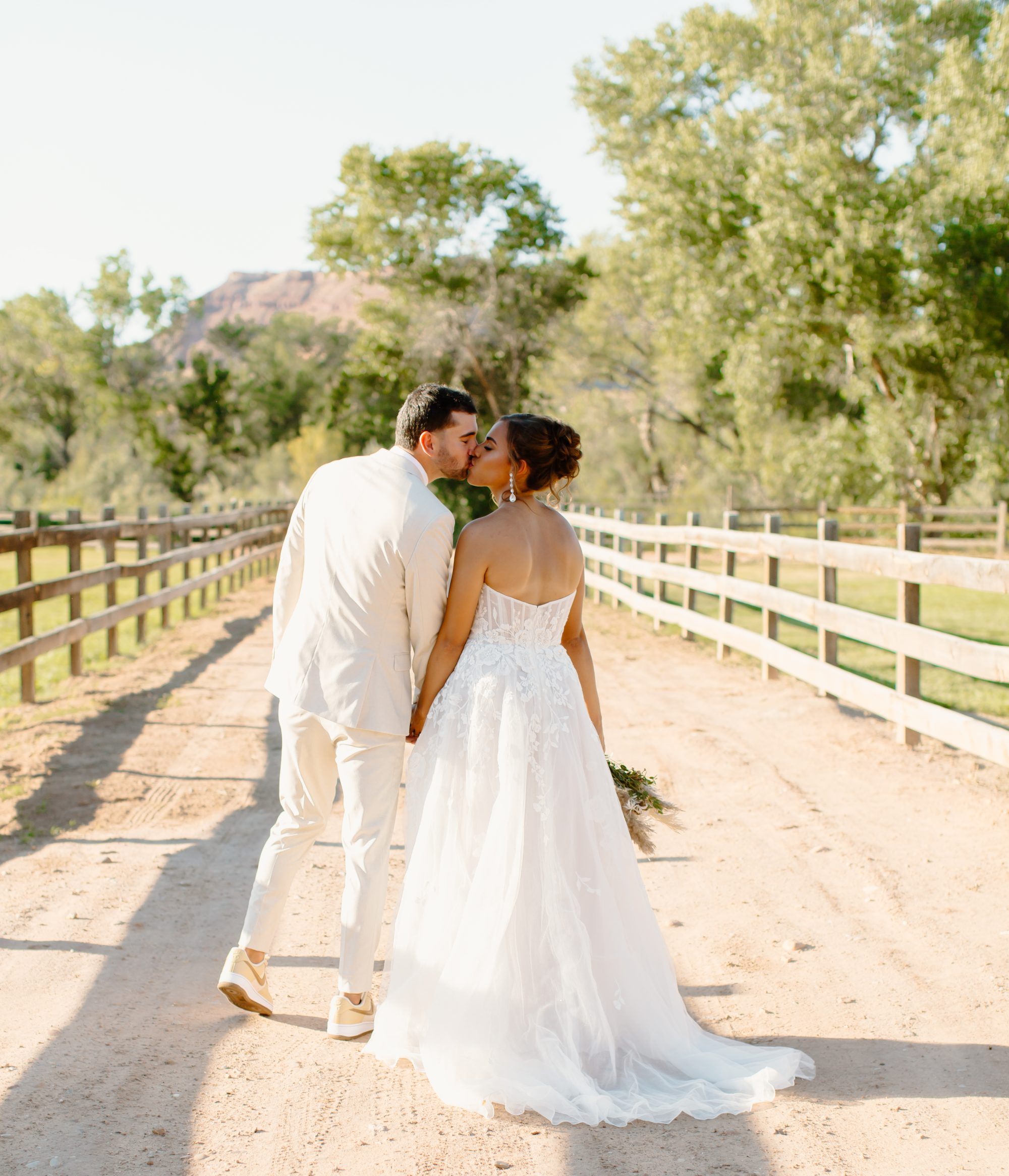 Lexi and Justin kissing on dirt road Southern Utah wedding